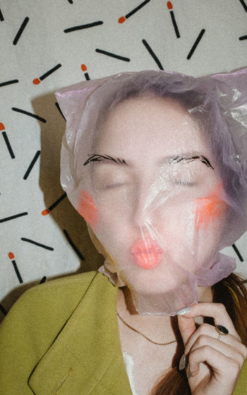 Close-up of woman covering face with plastic