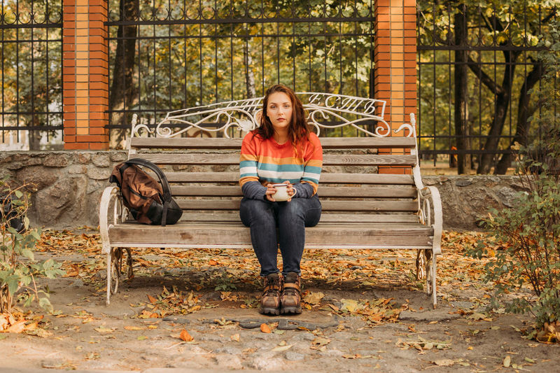Body shaming, low self-worth concept. sad plus size woman walking in autumn park.
