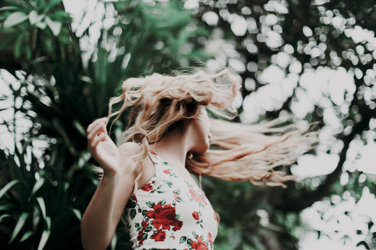 Blonde woman with fluttering hair on a tropic background