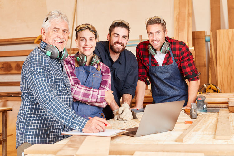 Portrait of cheerful carpenters at workshop