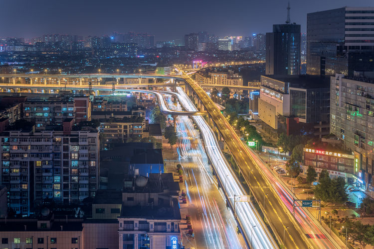 High angle view of illuminated street amidst buildings at night