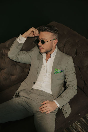 Young man wearing sunglasses sitting outdoors