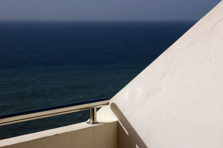Close-up of retaining wall by sea against sky