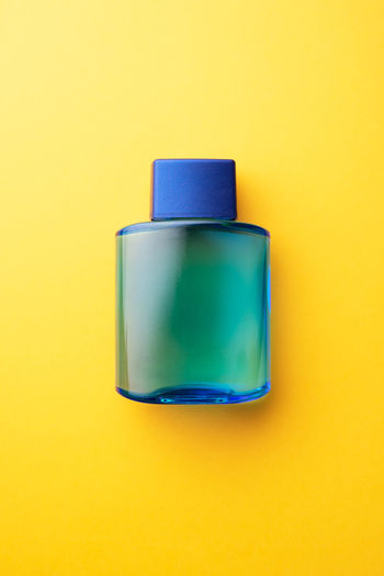 Close-up of blue glass against yellow background