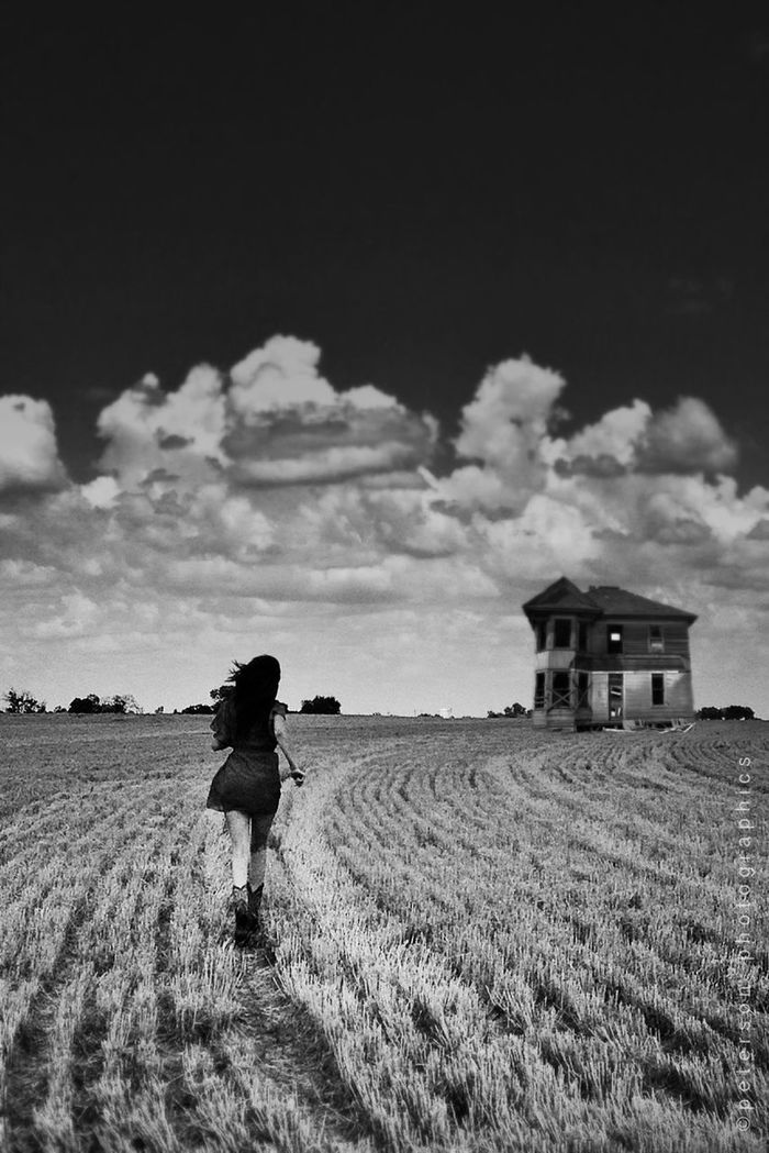 WOMAN STANDING ON FIELD AGAINST CLOUDY SKY