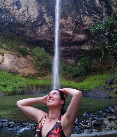 Woman standing in front of waterfall