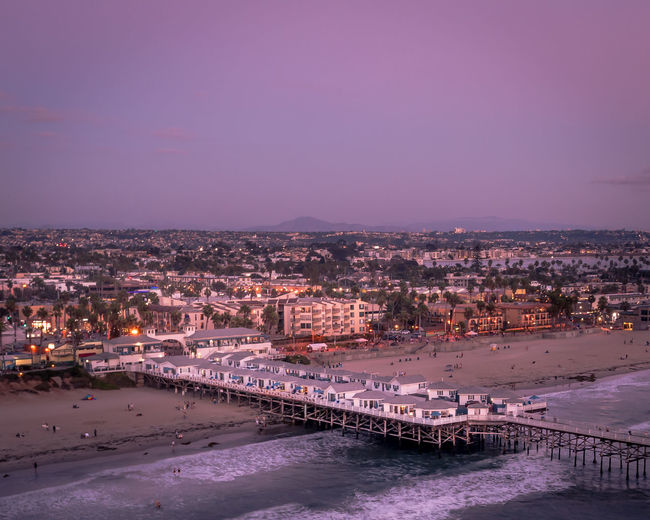 Drone view of crystal pier cottages hotel. san diego california sunset with city lights.