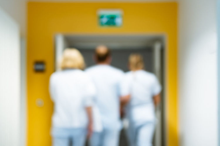 Rear view of people standing by door