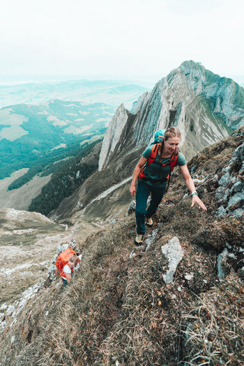 Two female climbers ascending steep mountain in switzerland