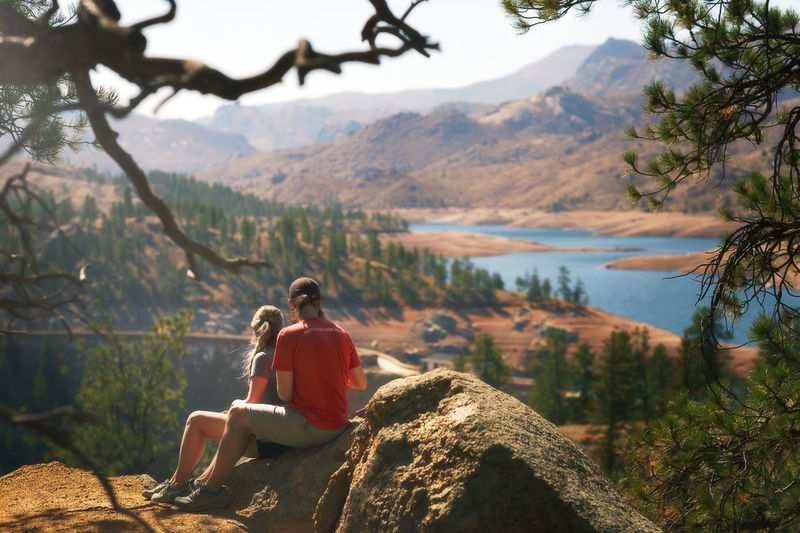 Man sitting on rock against mountains