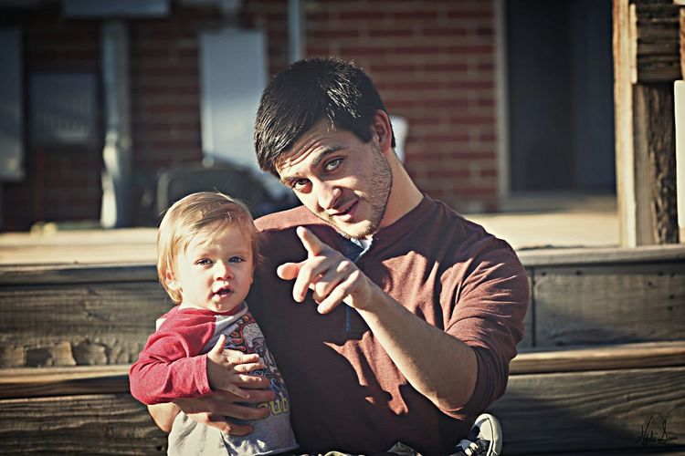 Portrait of father with cute son sitting on steps