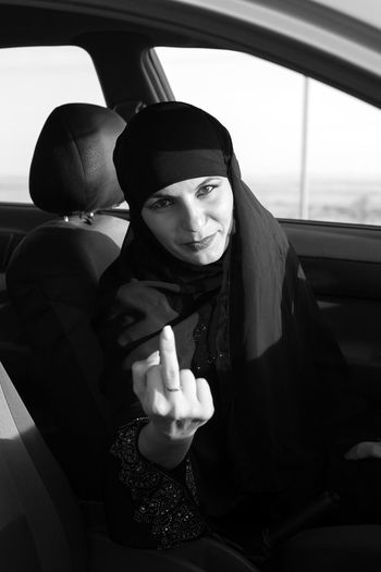 Portrait of woman gesturing while sitting in car