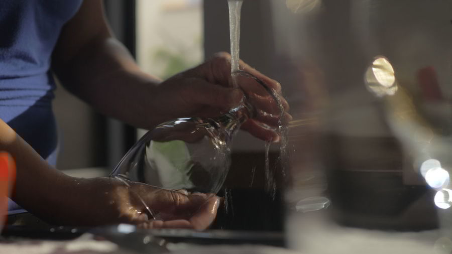 Midsection of woman cleaning wineglass