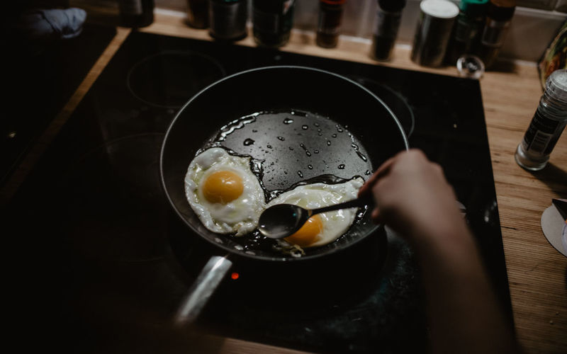 Midsection of woman preparing fried eggs