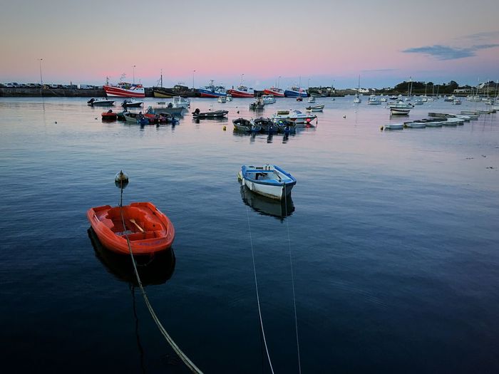 High angle view of boats moored in sea against sky during sunset