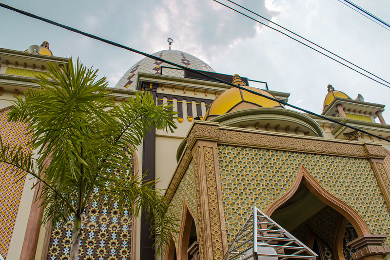 Low angle view photo of the mosque's dome in gold,and wrapped in cotton clouds