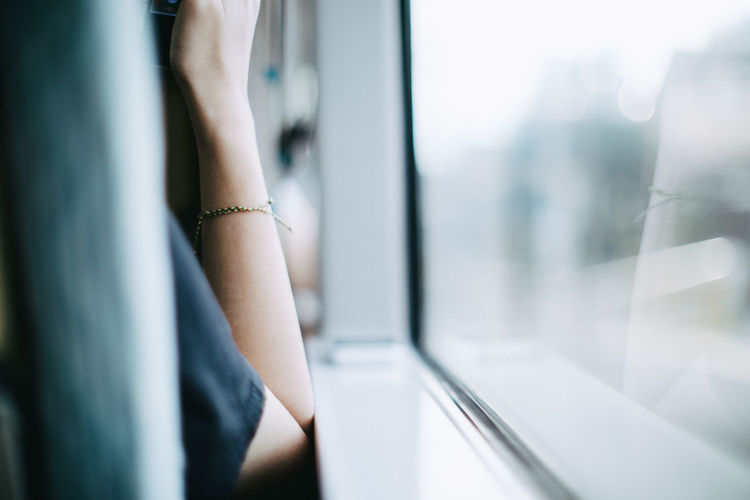 Cropped image of woman sitting by bus window