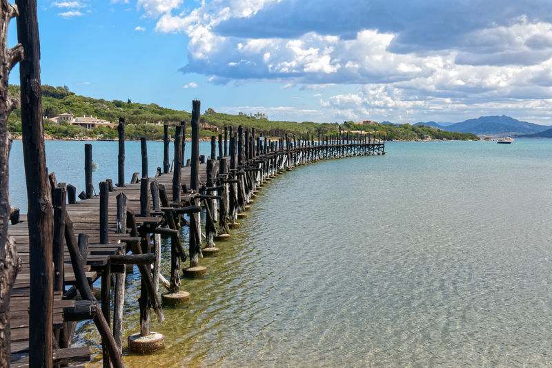 Wooden posts on beach against sky