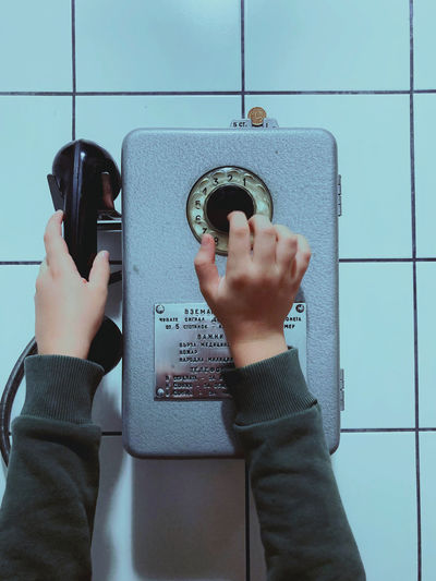 Cropped hands of child holding telephone