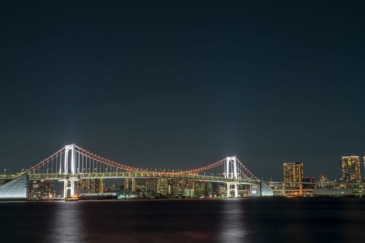 View of illuminated tokyo rainbow bridge over tokyo bay at night