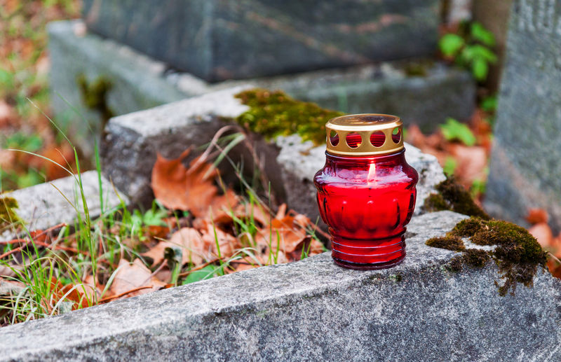 Close-up of red tea light candle on cemetery