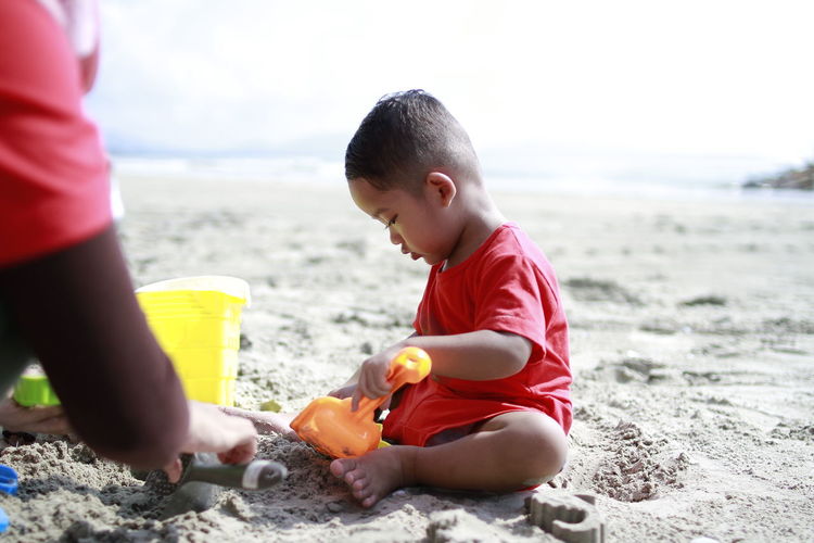 Boy playing with toys at beach
