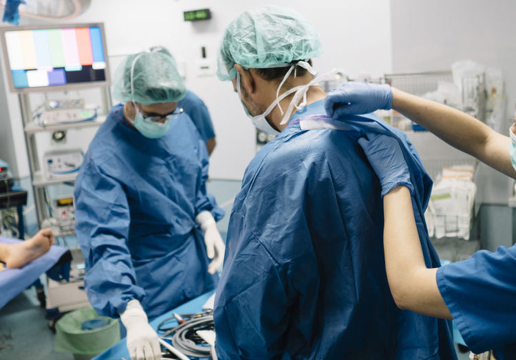 Female doctor helping orthopedic surgeon in operating room at hospital