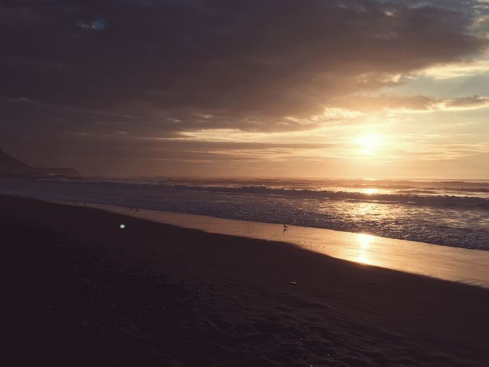Scenic view of beach against sky during sunset