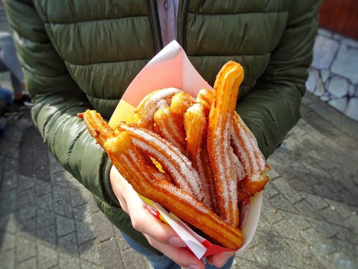 High angle view of person holding churros