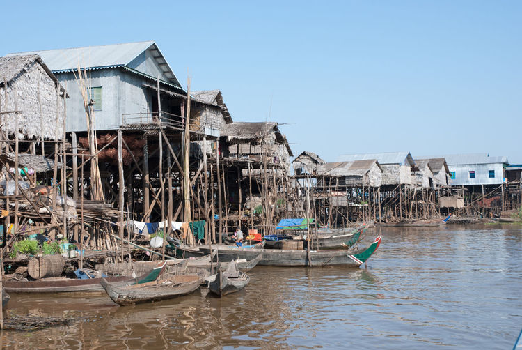 Boats moored by houses against clear sky