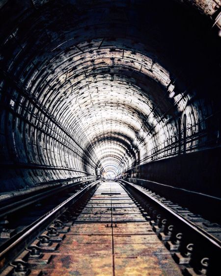 Empty railroad tracks in tunnel