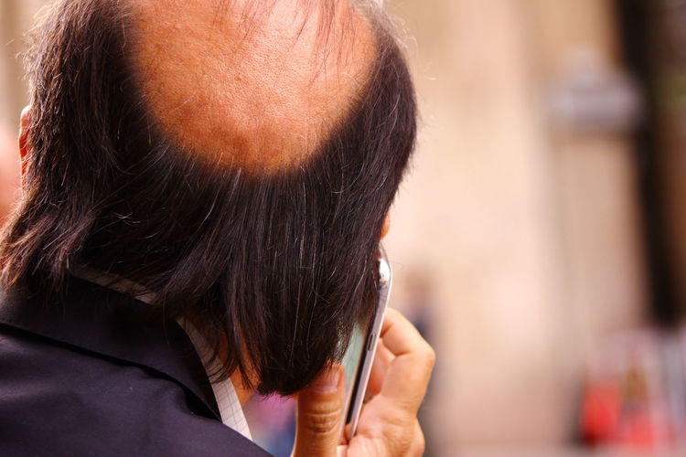 Rear view of man using smart phone