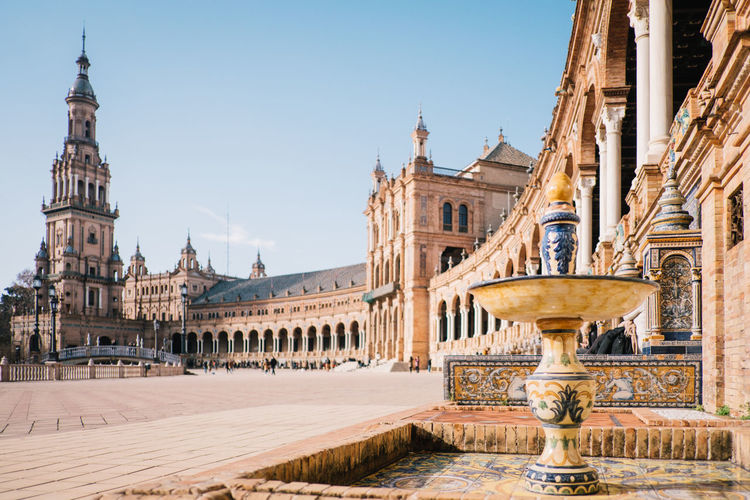 Low angle view of historic buildings at plaza de espana against blue sky