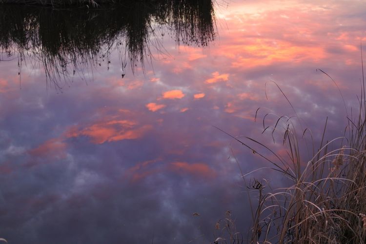 Scenic view of lake against sky at sunset