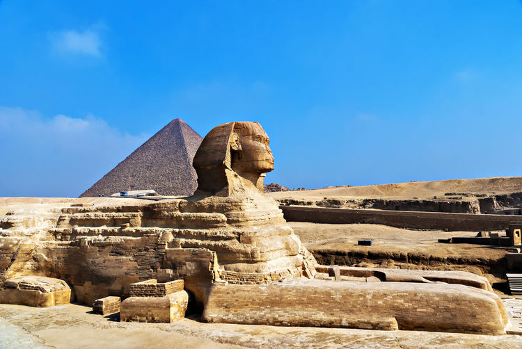 Side view of the sphinx against pyramid in egypt
