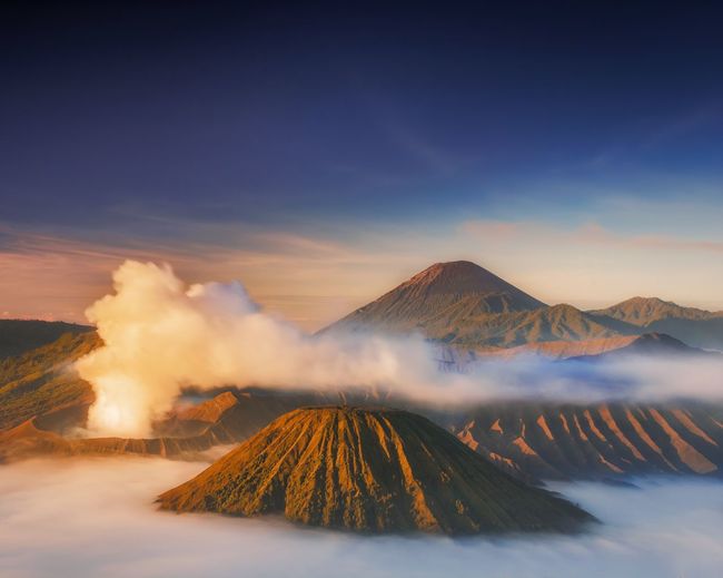 Scenic view of volcanic landscape against cloudy sky