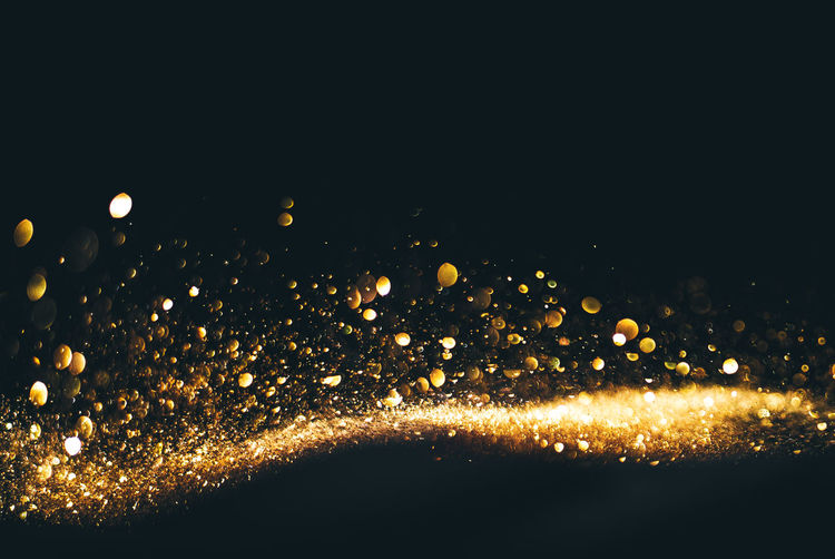 Close-up of gold glitter against black background