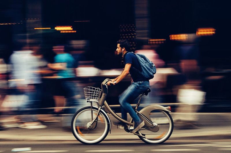 Side view of man riding bicycle on road