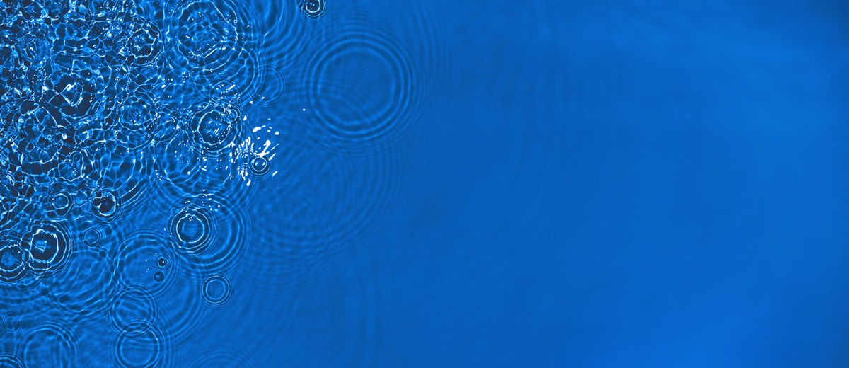 Transparent dark blue colored clear calm water surface texture