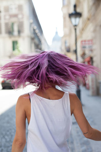 Rear view of woman with dyed hair walking on street