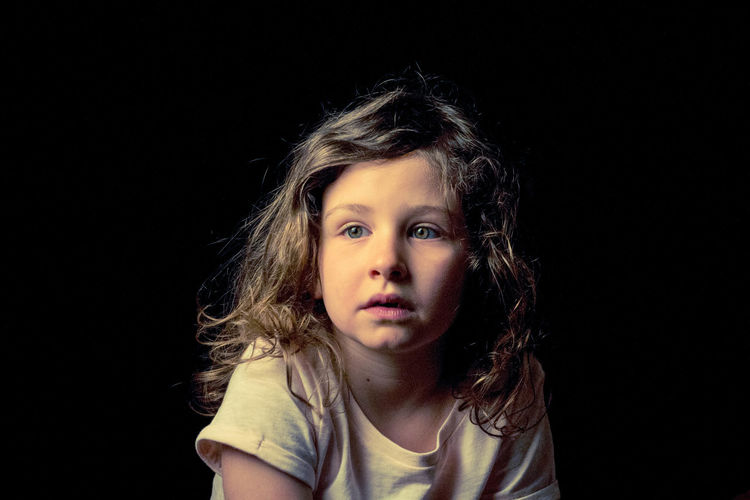 Portrait of girl against black background