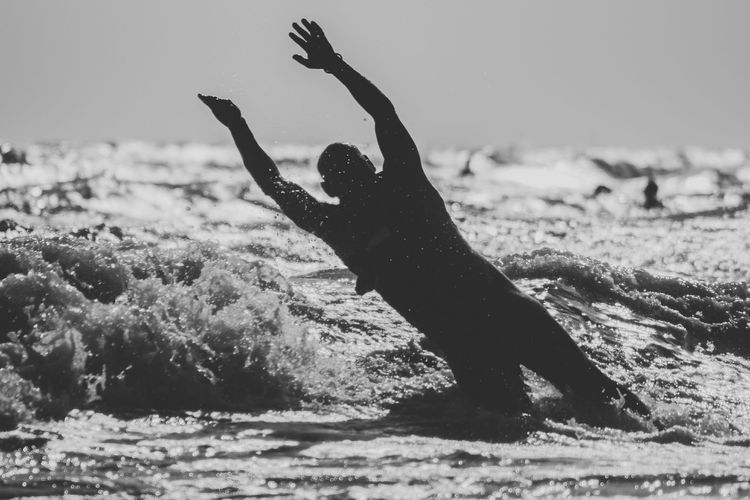 Man surfing on beach against sky