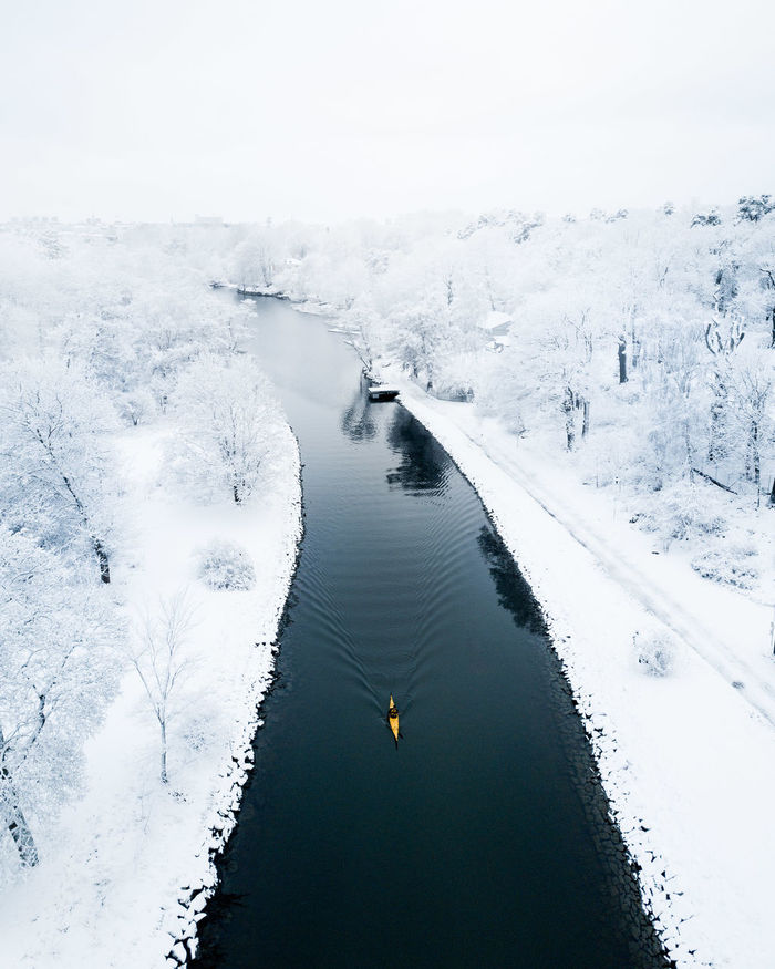 High angle view of river amidst snow covered field