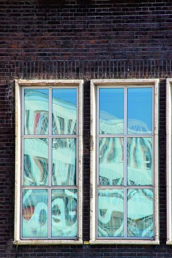 Full frame shot of glass window on brick wall
