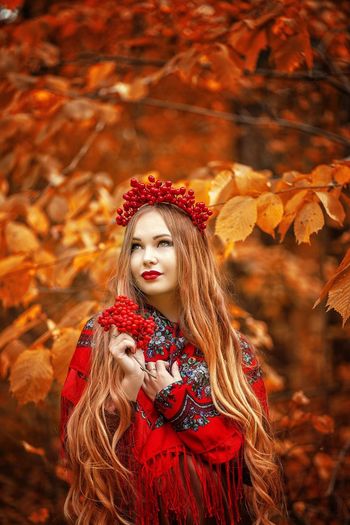 Portrait of woman with red leaves during autumn