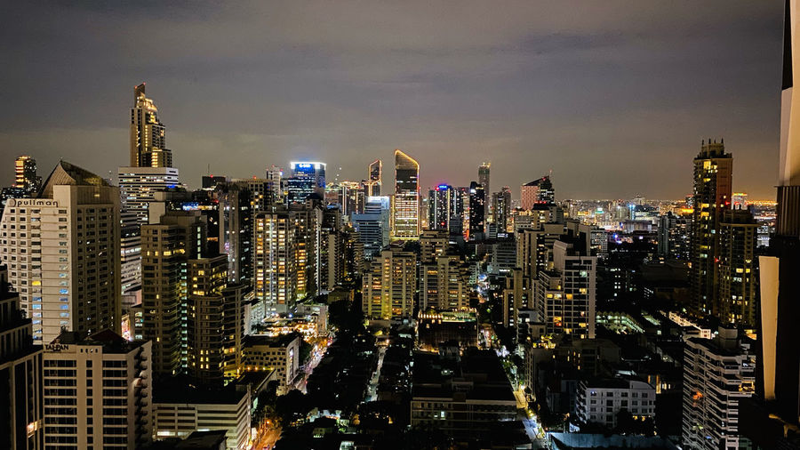 Illuminated cityscape against sky at night