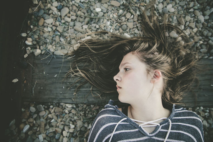 Portrait of young woman lying on railway track