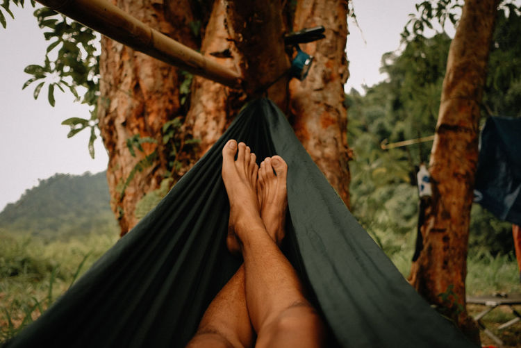 Low section of person relaxing on hammock