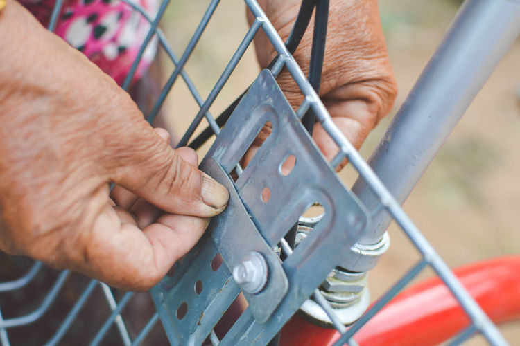 Close-up of cropped hand fixing bicycle basket