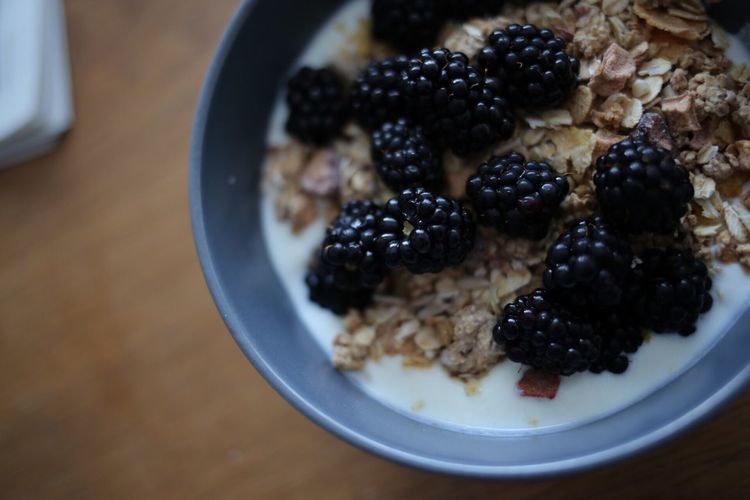 Close-up of blackberries on granola in bowl at table